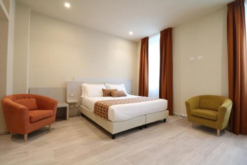 马瑞纳迪卡拉拉Doride Suites Boutique Hotel的酒店客房,配有一张床和两把椅子