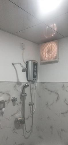 阿努拉德普勒苏顿鲁姆旅游度假酒店的带淋浴的浴室以及墙上的电视。