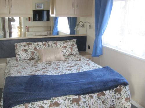 芬当Violet 28 Oakdene Forest Park的一间卧室配有一张带蓝色毯子的床