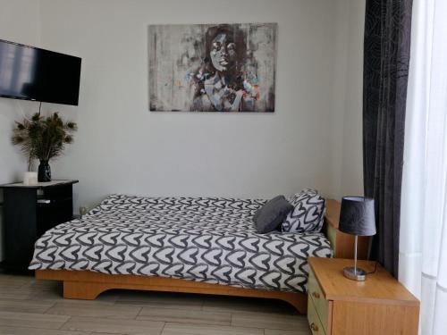 克宁Motel "Tri lovca"的卧室配有一张床,墙上挂有绘画作品