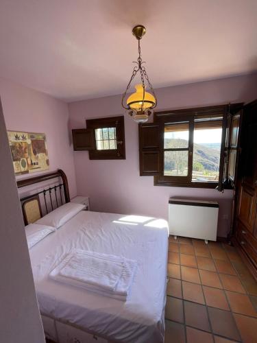 昆卡Apartamentos Hoz del Huécar的一间卧室配有一张床和一个吊灯