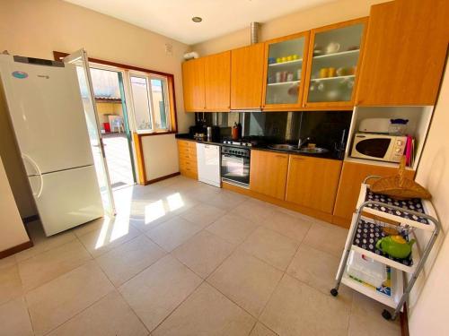 Vila ChãMindelo Beach House的厨房配有木制橱柜和白色冰箱。