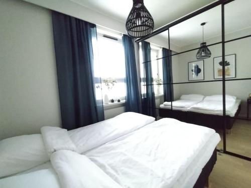波里Galle BnB boheemi kaksio的卧室配有一张白色大床和镜子