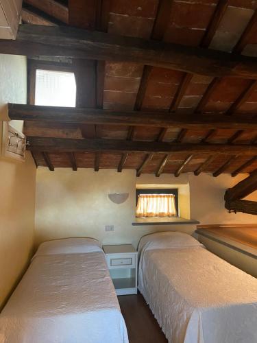 巴尼奥雷焦Hotel divino Amore的带窗户的客房内的两张床