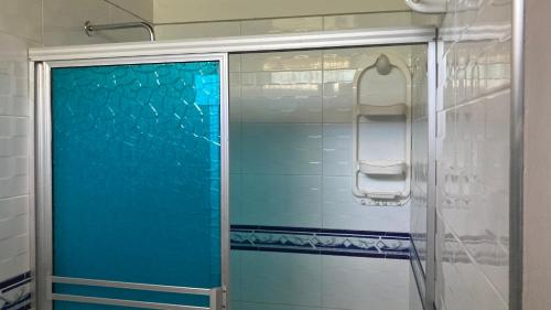 约帕尔Hotel El Broche的浴室里设有蓝色玻璃门淋浴