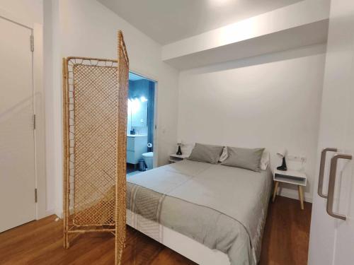 马塔罗Mazi Apartments Loft的白色卧室配有床和镜子