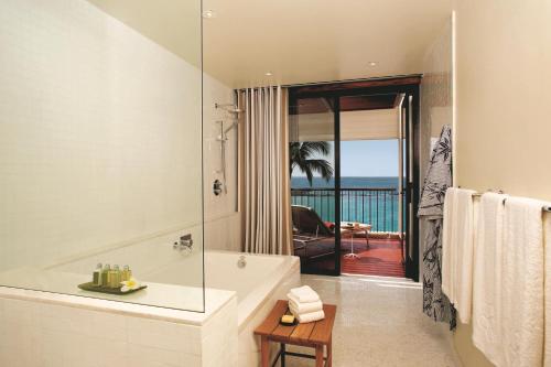 哈普那海滩傲途格精选酒店之冒纳凯阿火山海滩酒店的带浴缸的浴室,享有海景。
