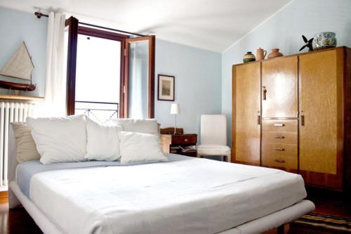贝拉诺Appartamento Relax Lago di Como的卧室配有白色大床和梳妆台