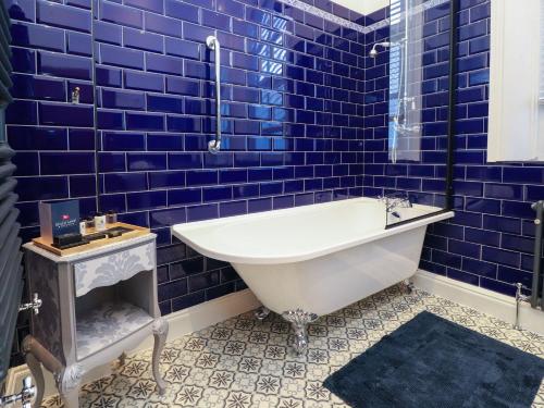 克罗斯比Ismay Dining Room Suite - Titanic Interest的蓝色瓷砖浴室设有白色浴缸