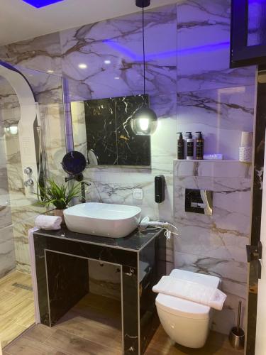 新马尔马拉斯Candi Luxury Suites的一间带水槽和大理石墙的浴室