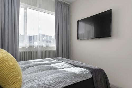 雷克雅未克NN Urban Guesthouse的一间卧室配有一张床和一台平面电视