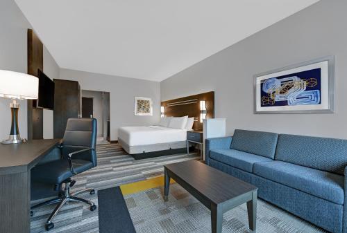 休斯顿Holiday Inn Express & Suites Memorial – CityCentre, an IHG Hotel的酒店客房配有一张床、一张沙发和一张书桌。