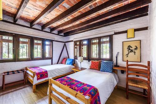 巴耶德布拉沃Agradable Cuarto de Hostal sobre el Centro, Valle的一间卧室设有两张床和木制天花板