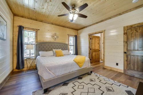 布罗肯鲍Family-Friendly Broken Bow Cabin Rental with Hot Tub的一间卧室配有一张床和吊扇