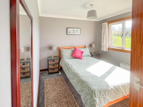 Powmill吉安乡村别墅的一间卧室设有一张床、一个窗口和一面镜子