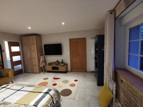 Sainte-Croix-sur-MerChambre de l'Iris的一间卧室配有床、电视和地毯。