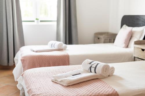 维拉摩拉老村及威望假日公园的客房内的两张床和毛巾