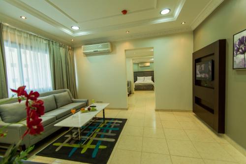 奥朱贝尔Baisan Suites Al Jubail的客厅配有沙发和桌子