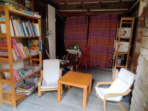 LohrLe havre de grès的一间设有两把椅子、一张桌子和书架的房间