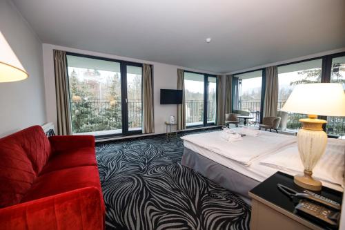 卡罗维发利卡尔斯巴德公园酒店的酒店客房,配有一张床和一张红色的沙发