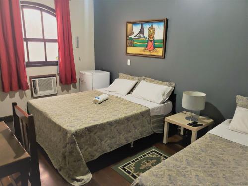 尼泰罗伊阿内霍望厦宾馆 的酒店客房带两张床和一张桌子以及椅子。