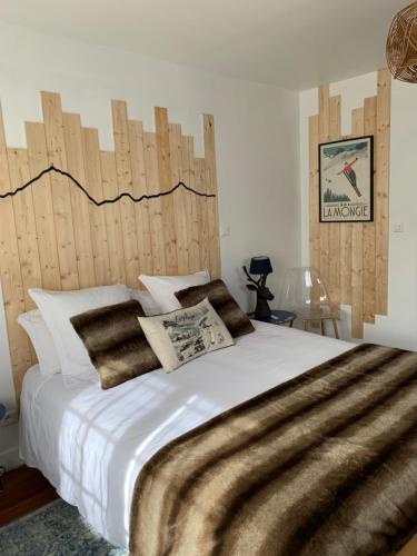GerdeLa Bigourdane的一间卧室配有一张大床和木制床头板