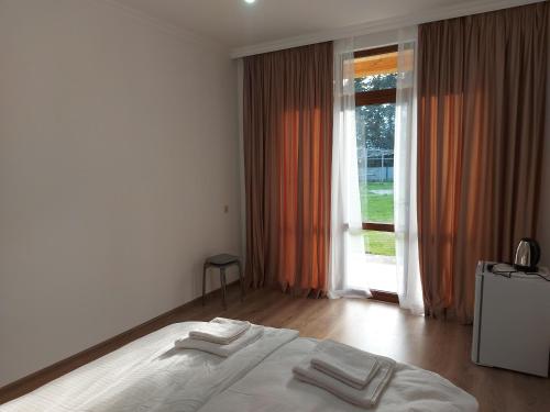 古达乌塔Diamond Eco Hotel的卧室配有白色的床和2条毛巾