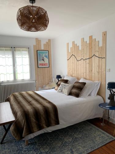 GerdeLa Bigourdane的一间卧室配有一张大床和木制床头板
