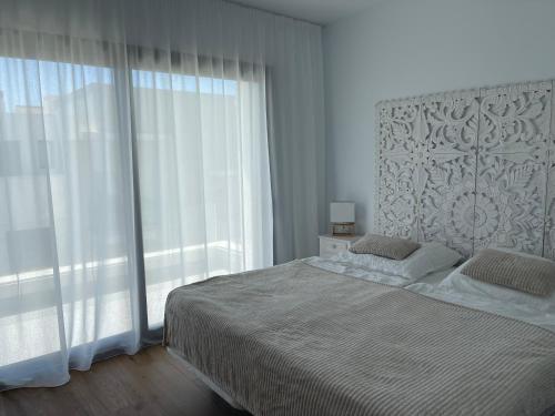 阿尔加德萨Links II 505 Duplex 2bedroom Apartment GOLF Alcaidesa SPAIN的一间卧室设有一张床和一个大窗户