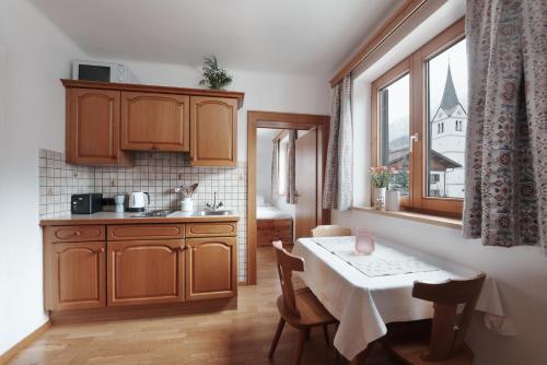 莱奥冈Appartement Leni Leogang的带桌子的厨房和带窗户的小厨房