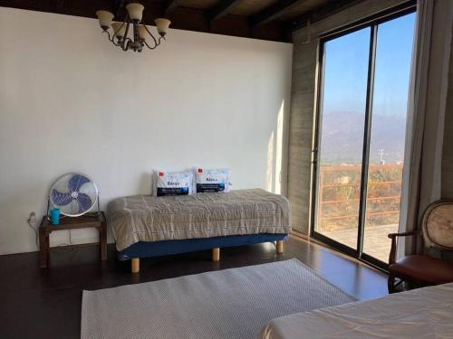 特卡特Cabaña Valzam 2 entre viñedos Rancho Tecate Resort的一间卧室设有一张床和一个大窗户