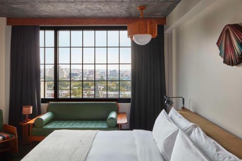 布鲁克林Ace Hotel Brooklyn的一间卧室设有绿色沙发和大窗户