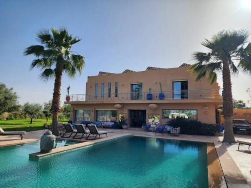马拉喀什Villa de rêve à Marrakech的房屋前有游泳池的房子
