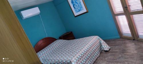 埃尔多拉多Estancia La Paulina的一间卧室设有一张床和蓝色的墙壁