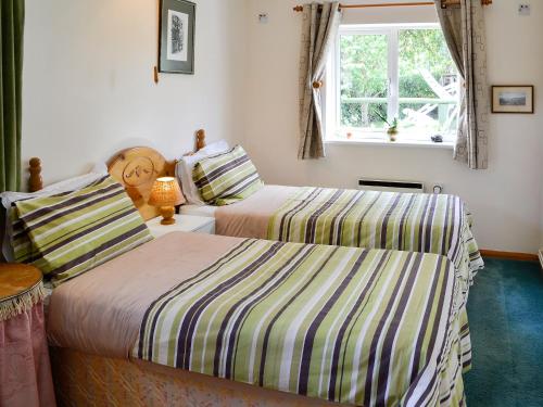 Isle Brewers罗塞特东翼度假屋的一间卧室设有两张床和窗户。