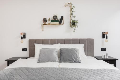 扎达尔Aura Exclusive Apartment & Room的一张带白色床单和灰色枕头的床
