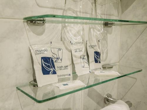 罗德里戈城Hostal Plaza的浴室内的玻璃架和洗浴用品