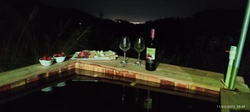 圣玛尔塔Glamping MINKAWAY的一张桌子,上面放着两杯葡萄酒和奶酪