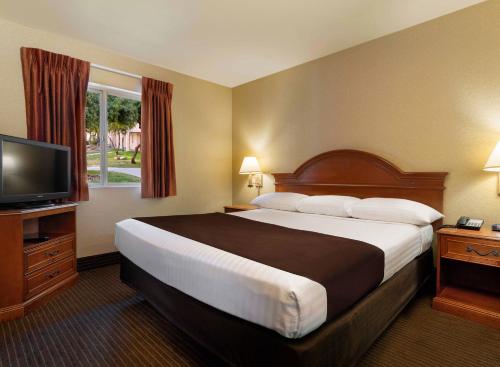 拉斯维加斯亚利桑那州查理博尔德酒店的一间酒店客房,配有一张大床和一台平面电视