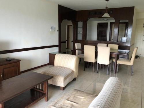 Kampong Alor GajahAisis Home at Afamosa的客厅配有桌子和白色椅子