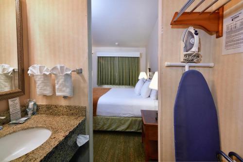 圣地亚哥Lamplighter Inn & Suites at SDSU的一间酒店客房 - 带一张床和一间浴室