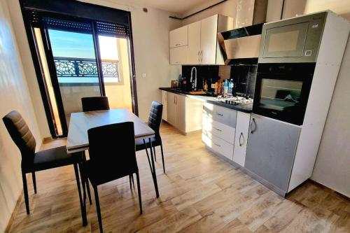 奥兰F4 vue sur mer的一间带桌椅的厨房和一间用餐室
