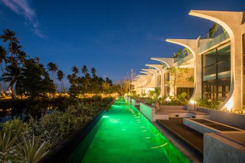 圣维森特The Hotel Elizabeth Resort and Villas - Long Beach San Vicente Palawan的一座在夜间有绿色走道的建筑