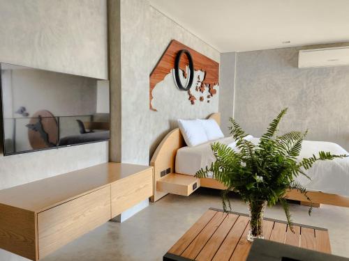 圣维森特The Hotel Elizabeth Resort and Villas - Long Beach San Vicente Palawan的一间卧室配有一张床和一张带盆栽的桌子