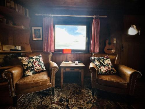 索尔布罗特拉卡巴尼酒店 的一间设有两把椅子、一张桌子和一个窗户的房间