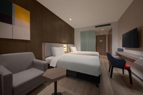 上海上海浦江智选假日酒店的一间卧室配有一张床、一张沙发和一把椅子