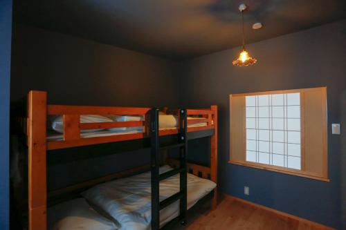 仓敷Temari Inn Madoromi的双层床间 - 带两张双层床和一扇窗户
