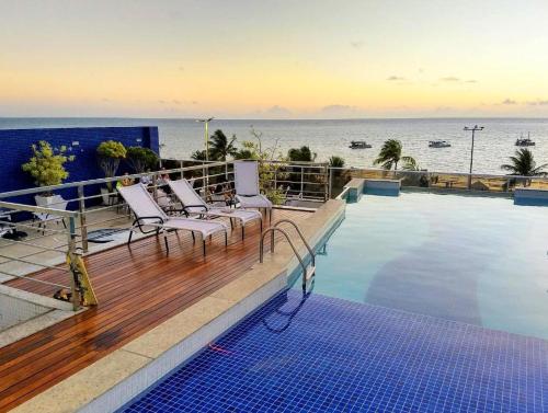 若昂佩索阿Tambaú Home Beira Mar - com varanda的一个带椅子的游泳池,享有海景