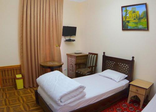 布哈拉Madina-Mehribon Welcome to Bukhara的一间小卧室,配有一张床和一张书桌