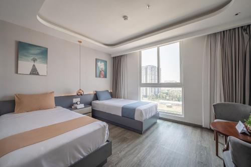胡志明市Cozrum Homes - Sonata Residence的酒店客房,配有两张床和椅子
